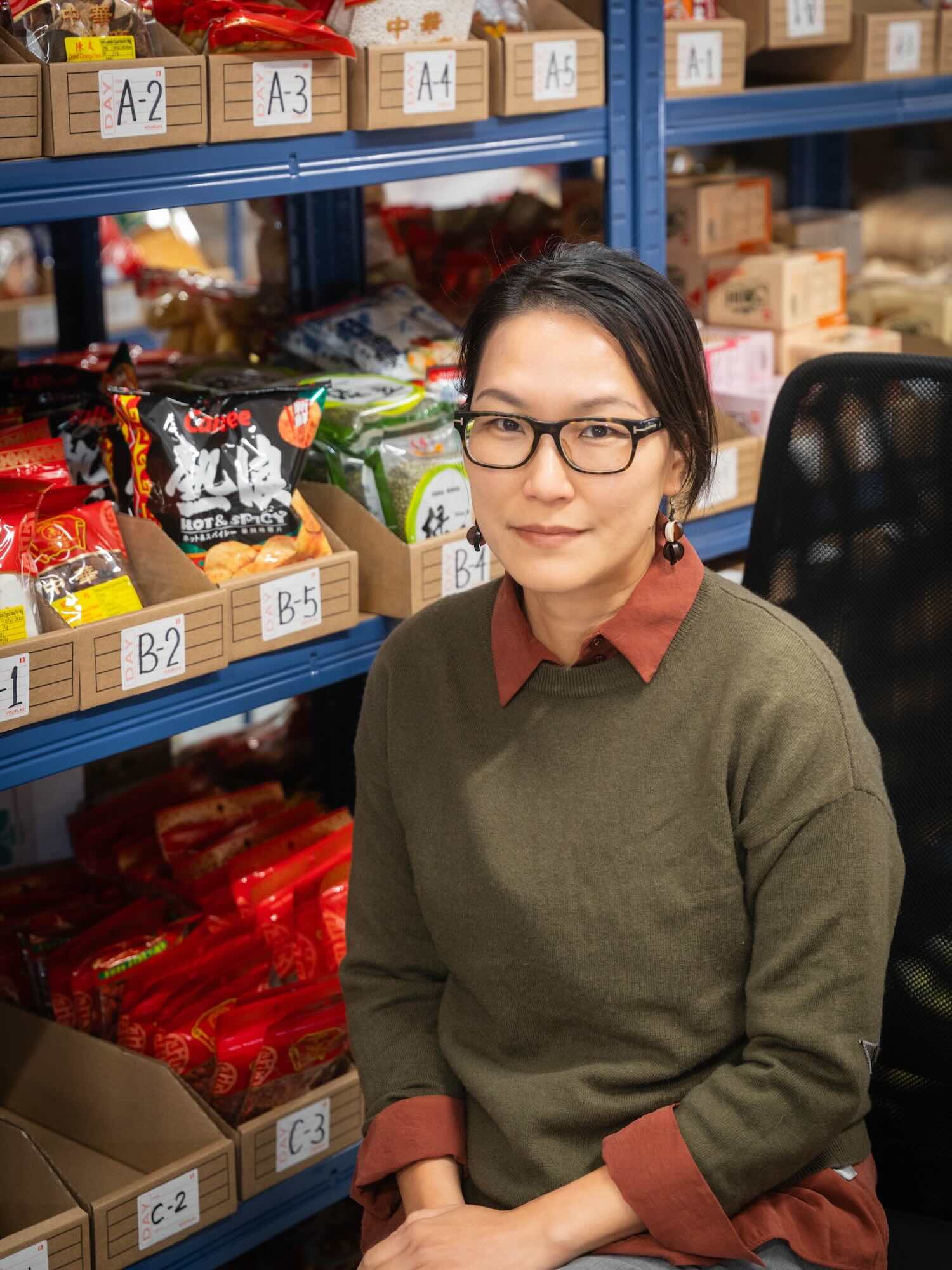 Hong Kong store manager surrounded by local products in the warehouse
